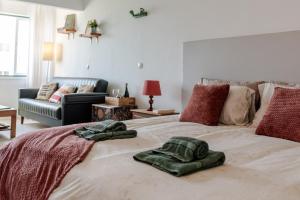 a bedroom with a bed with two towels on it at Seaview Ensuite rooms in Sagres centre - Casa Maluka in Sagres