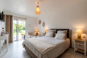 - une chambre avec un grand lit et une porte coulissante en verre dans l'établissement Gîte & Chambres d'Hôtes - Le Petit Bali, à Saint-Pandelon
