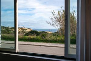 a window with a view of the ocean through it at Seaview Ensuite rooms in Sagres centre - Casa Maluka in Sagres