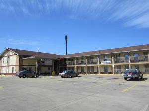 a large building with cars parked in a parking lot at First Western Inn - Fairmont City in Fairmont City