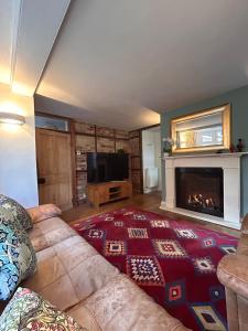 ein Wohnzimmer mit Couch und Kamin in der Unterkunft Flora Cottage, in the heart of the city in Salisbury