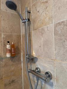 eine Dusche mit Duschkopf in einem Badezimmer in der Unterkunft Flora Cottage, in the heart of the city in Salisbury
