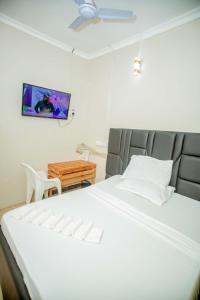 a bedroom with a bed and a tv on the wall at WayPoint Lodge in Dar es Salaam +8 photos