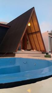ein Haus mit einem schwarzen Dach und einem Pool in der Unterkunft Pinggan glamping ground in Gretek