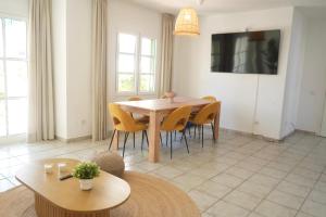 a dining room with a wooden table and chairs at Pura Vida by Maspalomas Holiday Villas in Pasito Blanco +47 photos