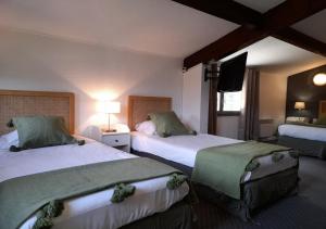 a hotel room with two beds and a flat screen tv at Les Jardins de L'Ocean - Climatisé in Biscarrosse-Plage