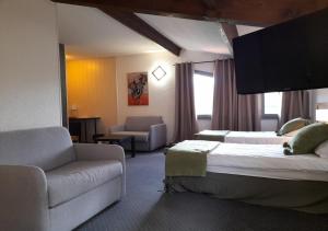 a hotel room with two beds and a couch at Les Jardins de L'Ocean - Climatisé in Biscarrosse-Plage