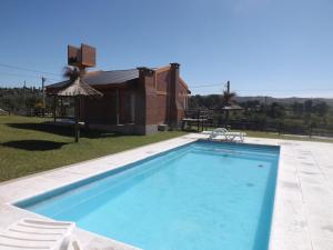 a swimming pool in a yard with a house at Cabañas San Jose in Potrero de Garay