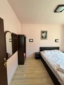 Un dormitorio con una cama y suelo de madera. en VIP Complex, en Sarnitsa