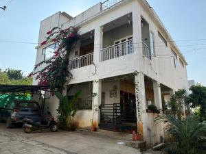 a white building with flowers on the side of it at CozyNest Retreat in Belgaum