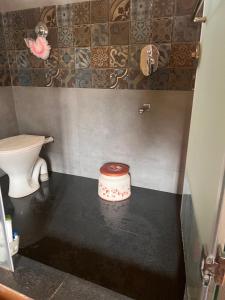 a small bathroom with a toilet and a sink at CozyNest Retreat in Belgaum +8 photos
