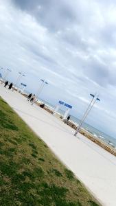 einen Bürgersteig mit blauen Schildern am Strand in der Unterkunft Luxury beachfront apartment in Martil + 4 Fotos