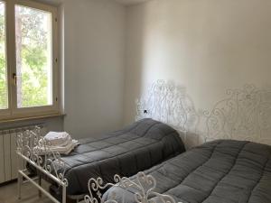 a bedroom with two beds and a window at Meris affittacamere in Monsano