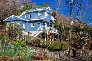 a blue house on the side of a hill at AZUR 伊豆熱川 aurora in Higashiizu