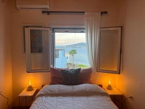 a bedroom with a bed and a window with a view at Perdika's Nest, family friendly house by the sea in Perdika