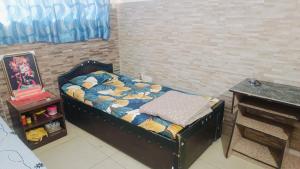 a small bed in a room with a table at Banke Bihari Spiritual Stay in Vrindāvan +9 photos