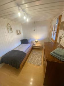a small bedroom with a bed and a desk at Cosy apartment in heritage protected swiss chalet in Interlaken