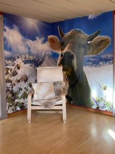 a room with a cow painting on the wall at Cosy apartment in heritage protected swiss chalet in Interlaken