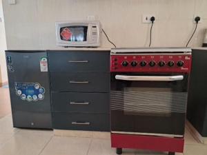 a kitchen with a stove and a microwave at Nash issah - 2BEDROOM Excutive Air in Nakuru