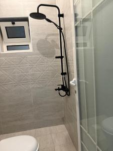a bathroom with a shower with a toilet and a shower head at ندا التوفيق للوحدات السكنية in Al Hofuf +8 photos