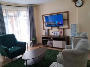 a living room with two chairs and a tv at Nash issah - 2BEDROOM Excutive Air in Nakuru +9 photos