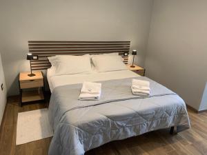 une chambre avec un grand lit avec deux serviettes dessus dans l'établissement B&B Tanda Rooms Olbia, à Olbia