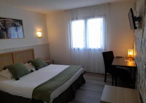 a hotel room with a bed and a desk and a window at Les Jardins de L'Ocean - Climatisé in Biscarrosse-Plage