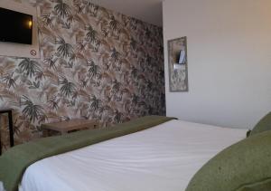 a bedroom with a white bed and a wallpaper with palm trees at Les Jardins de L'Ocean - Climatisé in Biscarrosse-Plage