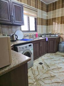 a kitchen with a washing machine and a sink at Jerash Heritage Stay in Jerash