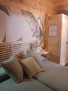 a bedroom with a bed with a painting on the wall at Cabaña Ikizen II in Barbadillo del Pez