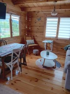 a log cabin living room with a table and a couch at Cabaña Ikizen II in Barbadillo del Pez