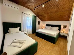 a bedroom with two beds and a wooden ceiling at Lakeview Escape Koman in Koman +23 photos