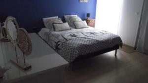 a bed in a bedroom with a blue wall at Chambre,petit déjeuner inclus in Chantonnay