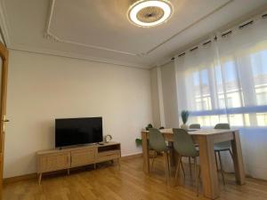a dining room with a table and a television at Piso Turístico Navarrete in Navarrete