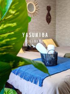 うるま市にあるIndependent House 沖縄VILLA YASUMIBA Okinawa Urumaのベッド1台(青い毛布、タオルバスケット付)