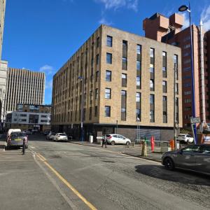 an empty street with cars parked in front of a building at Luxury Flat in Birmingham City West Midlands in Birmingham