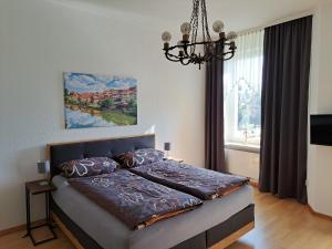 ein Schlafzimmer mit einem großen Bett mit Kronleuchter in der Unterkunft Ferienwohung Villa Cäcilie in Bad Sooden-Allendorf
