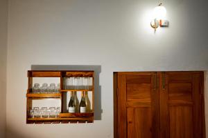 un estante con botellas de vino y un armario en Nook at Adviga by The Staycationer, en Rājpur