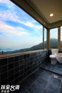 un bagno con due servizi igienici e una grande finestra di Good Time B&B a Jiufen
