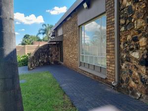Un edificio de ladrillo con una pasarela junto a una ventana. en TANS Guest suite, en Centurion