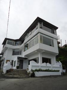 una grande casa bianca con delle scale davanti di Good Time B&B a Jiufen
