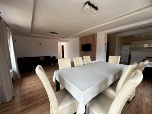 a white table and chairs in a living room at Gyopár Panzió & Kulcsoház in Izvoru Mureşului