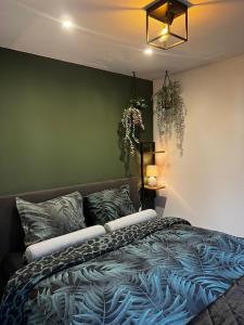 sypialnia z łóżkiem i zieloną ścianą w obiekcie CAPFUN luxe chalet Onthaasten op de Veluwe za tm za w mieście Doornspijk