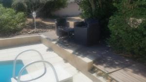 two trash cans sitting next to a swimming pool at VILLA AVEC PISCINE au calme ! in Rochefort-du-Gard