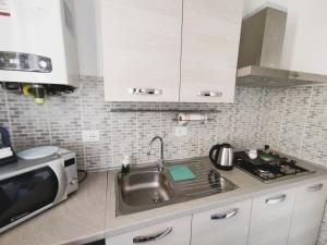 a kitchen with a sink and a microwave at La Casina di Orsolina - Check-in Flessibile in Livorno