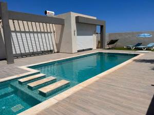 a swimming pool with stairs next to a house at Villa Mykonos sans vis a vis in Arkou