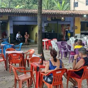 un groupe de personnes assises aux tables et aux chaises dans l'établissement Casa no Centro de Tinguá, à Nova Iguaçu