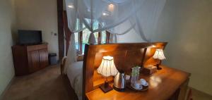 a bedroom with a table with two lamps on it at Prayatna Villas in Ubud
