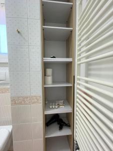 einen begehbaren Kleiderschrank mit weißen Regalen und einem Waschbecken in der Unterkunft Family Apartment Vista Lago in Stresa