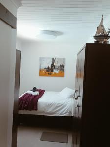a bedroom with a bed and a picture on the ceiling at The Pool Cottage in Fish hoek